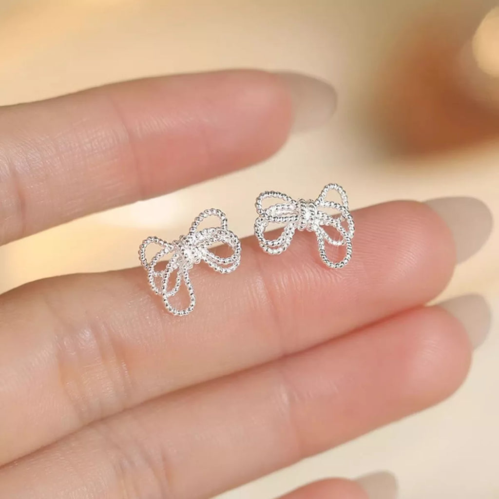 Sterling silver bow knot stud earrings with a polished finish, featuring a delicate and elegant design for everyday wear