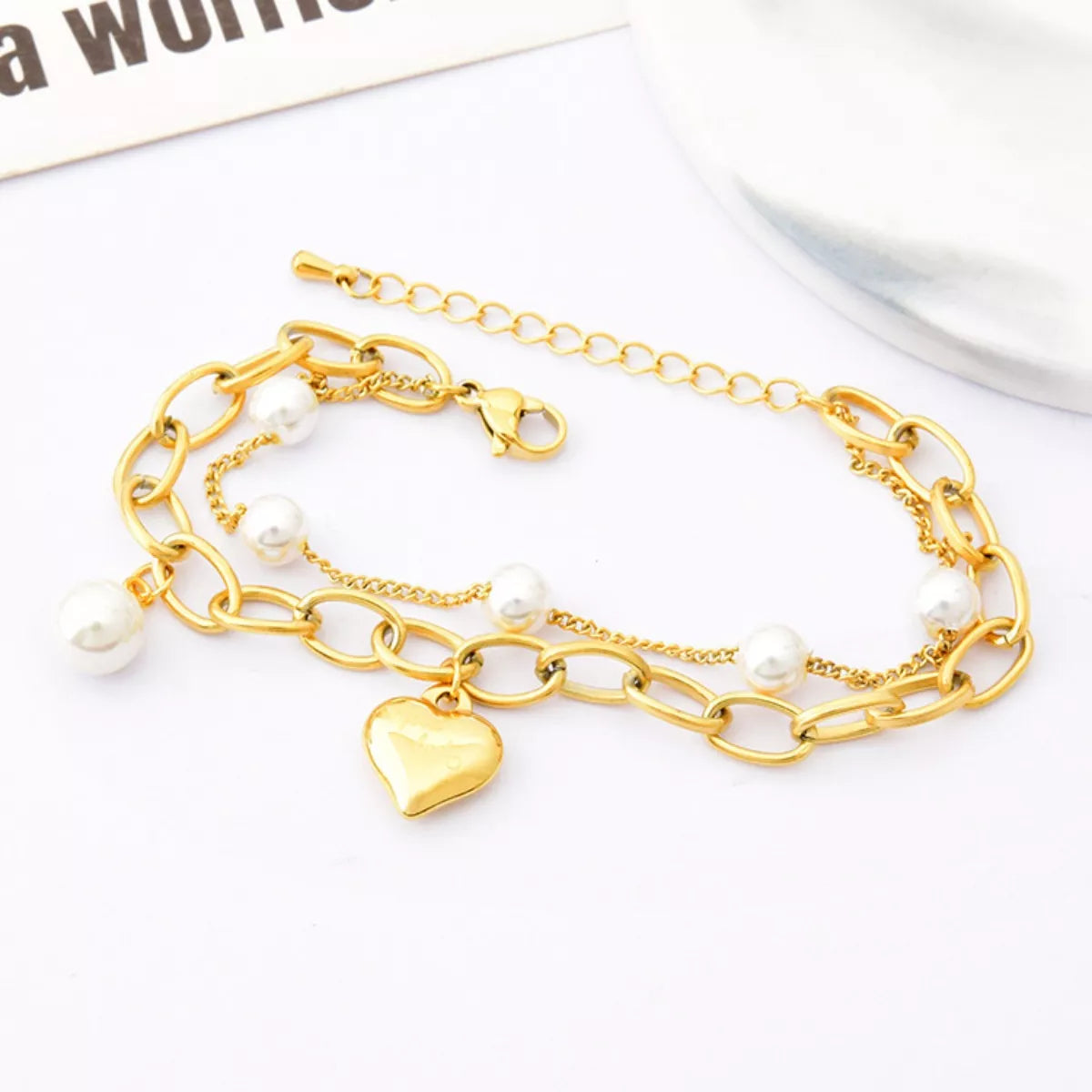 18K gold-plated heart charm bracelet with delicate chain and heart pendants, showcasing elegant jewelry design.