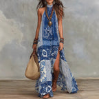Women's printed halterneck split maxi dress by Plush Fashion Hub, sleeveless, loose fit, flowy design with vibrant pattern.