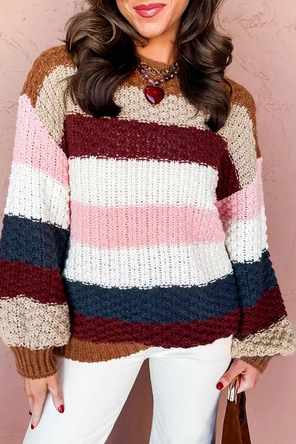 Striped knit dropped shoulder round neck sweater by Trendsi, featuring cozy fabric and casual style in a vibrant striped pattern.