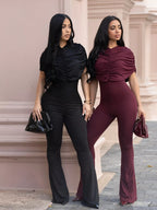 Rust-colored ruched flare leg jumpsuit from Trendsi, featuring a fitted bodice and wide-leg design.