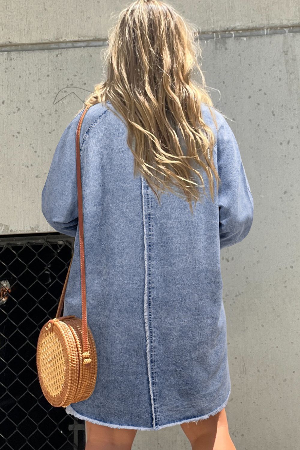 VYSN raw hem button-down long sleeve denim dress hanging on a rack, showcasing casual fashion style and classic denim design.