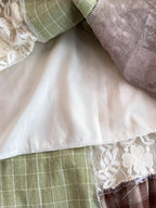 Boho patchwork lace-trimmed A-line tiered dress with bohemian style, featuring layered fabric and intricate lace details.