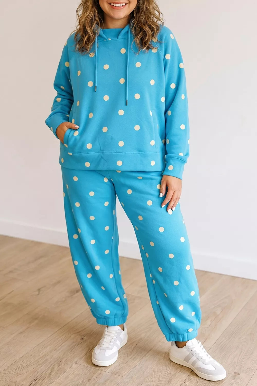 Plus size polka dot hooded drawstring long sleeve top and matching pants set by Trendsi, featuring stylish polka dot pattern and comfortable fit.