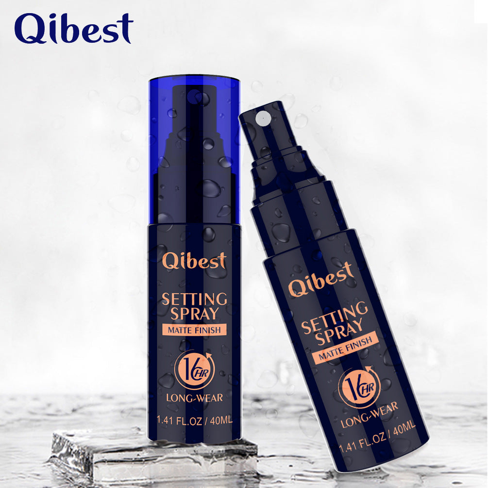 Two dark blue plastic Qibest matte setting spray bottles, one upright and one tilted, with gold text and water drops.