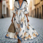 Women's floral print maxi dress with deep V-neck and flare sleeves, casualwear by Plush Fashion Hub, shown on a model.
