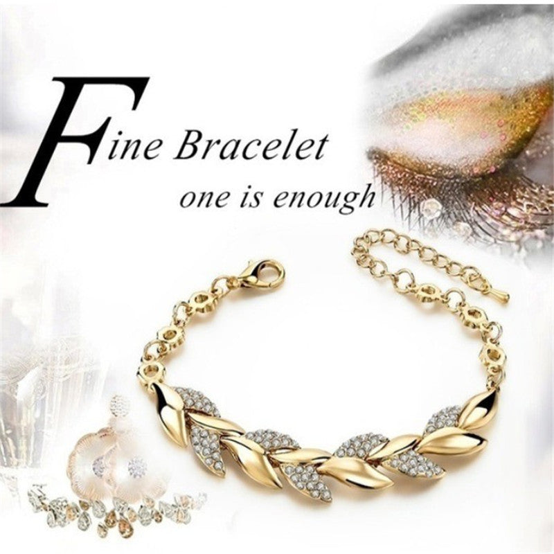 Gold metal leaf-pattern bracelet with crystal accents and adjustable chain.