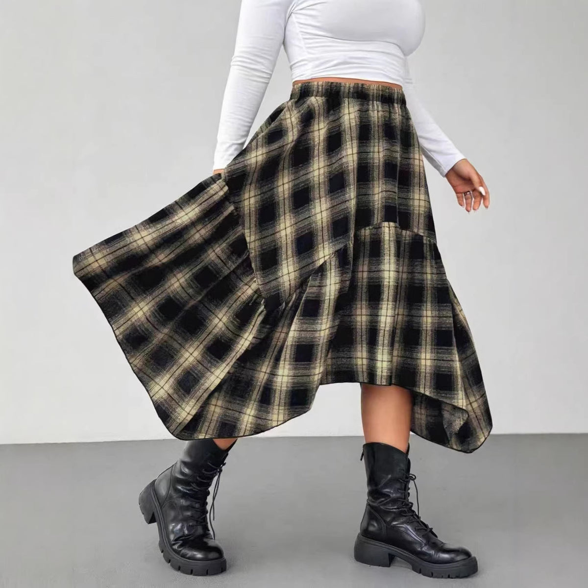 Black and beige plaid midi skirt with asymmetric hem and elastic waist, paired with black combat boots.