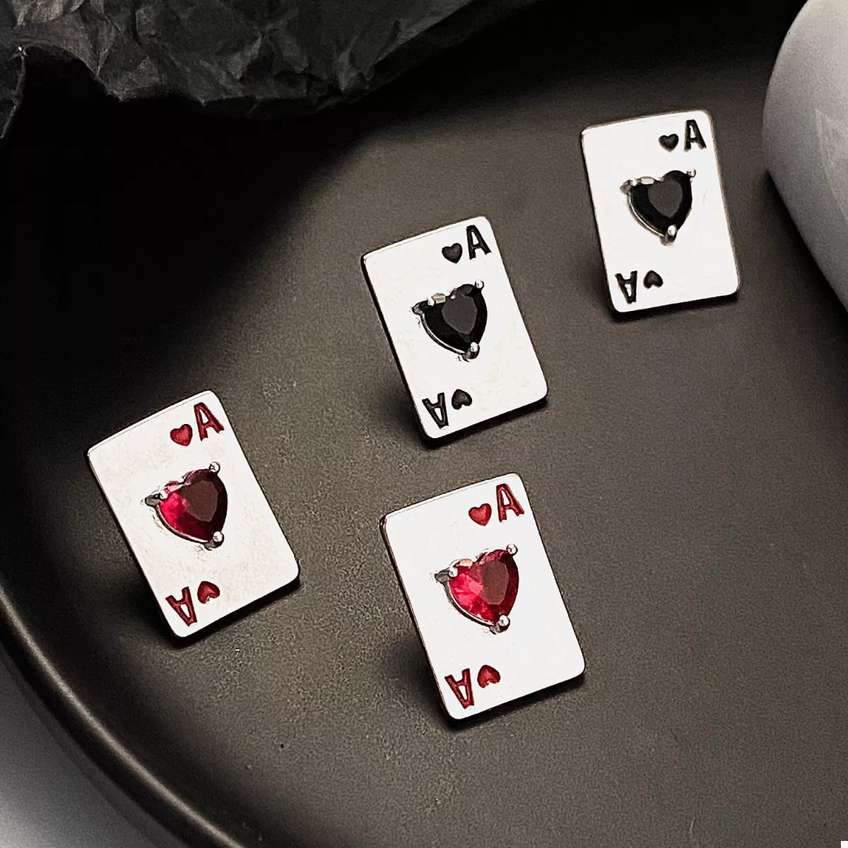 Plush Fashion Hub Ace of Hearts poker card stud earrings featuring a red heart design on a silver-tone setting.