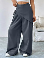 Asymmetrical wrap wide-leg pants by Plush Fashion Hub featuring a flowy design and stylish silhouette.