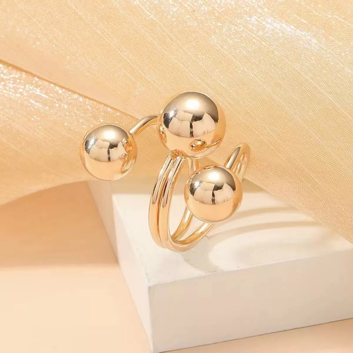 Shopimist multi-layered ball ring featuring stacked silver bands with textured and smooth finishes on a white background.