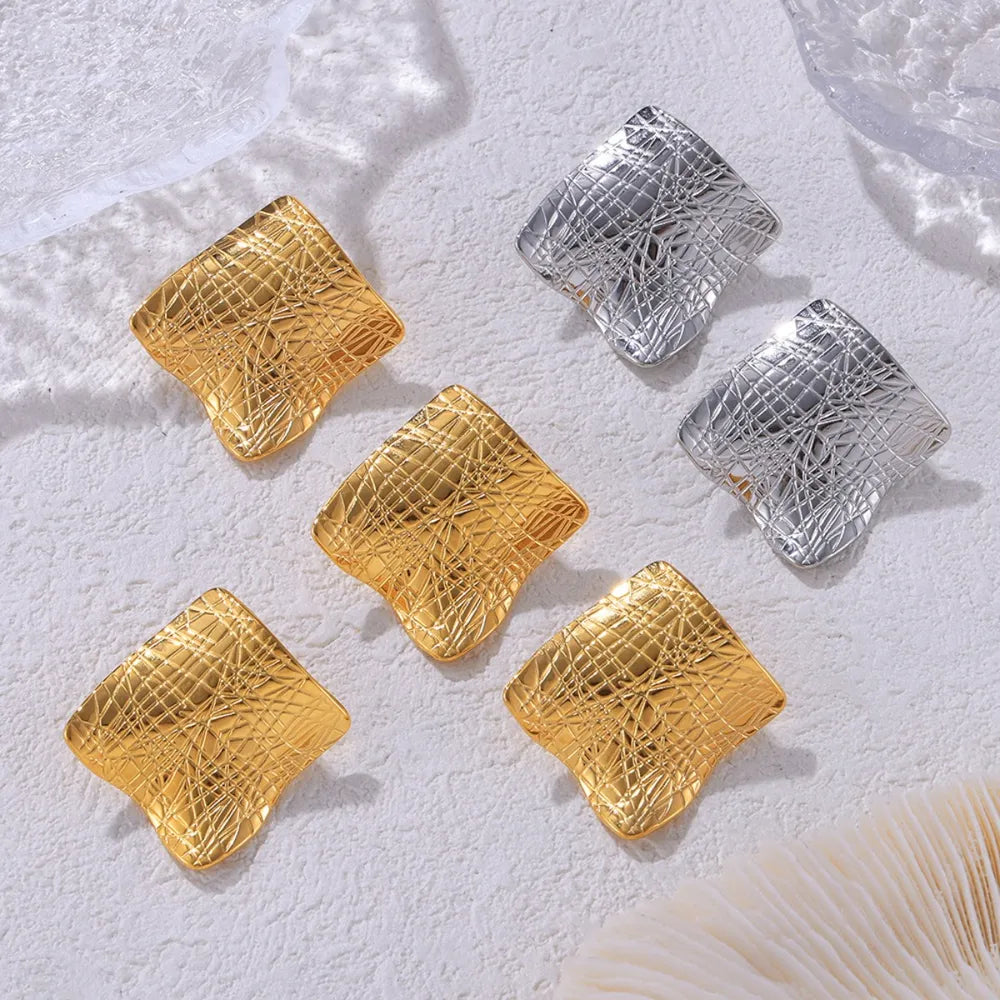 Textured titanium steel stud earrings with a sleek, modern design, featuring a polished finish and secure post back.