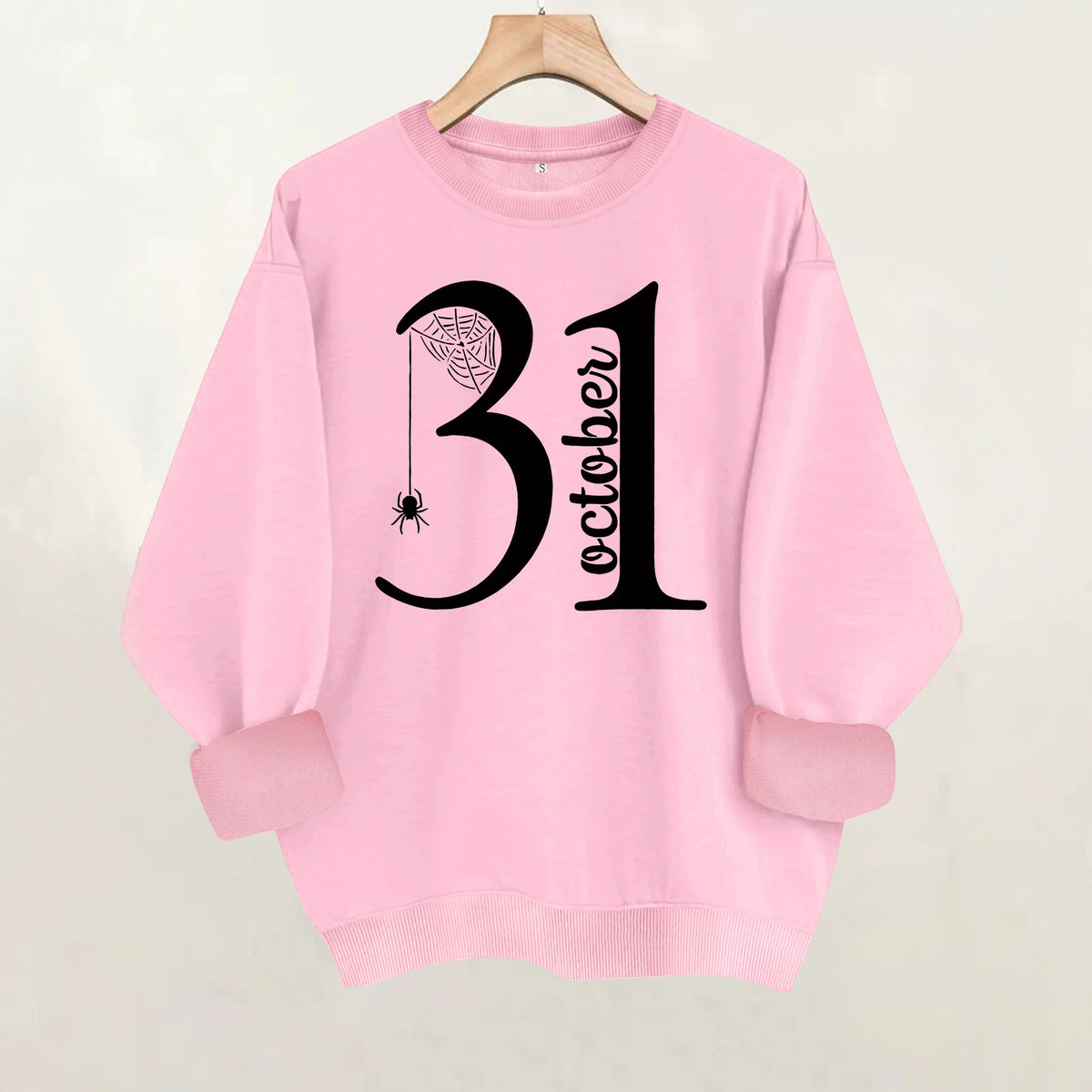 Pink cotton crewneck sweatshirt featuring a black graphic of the number 31 with "October", a web, and a hanging spider.