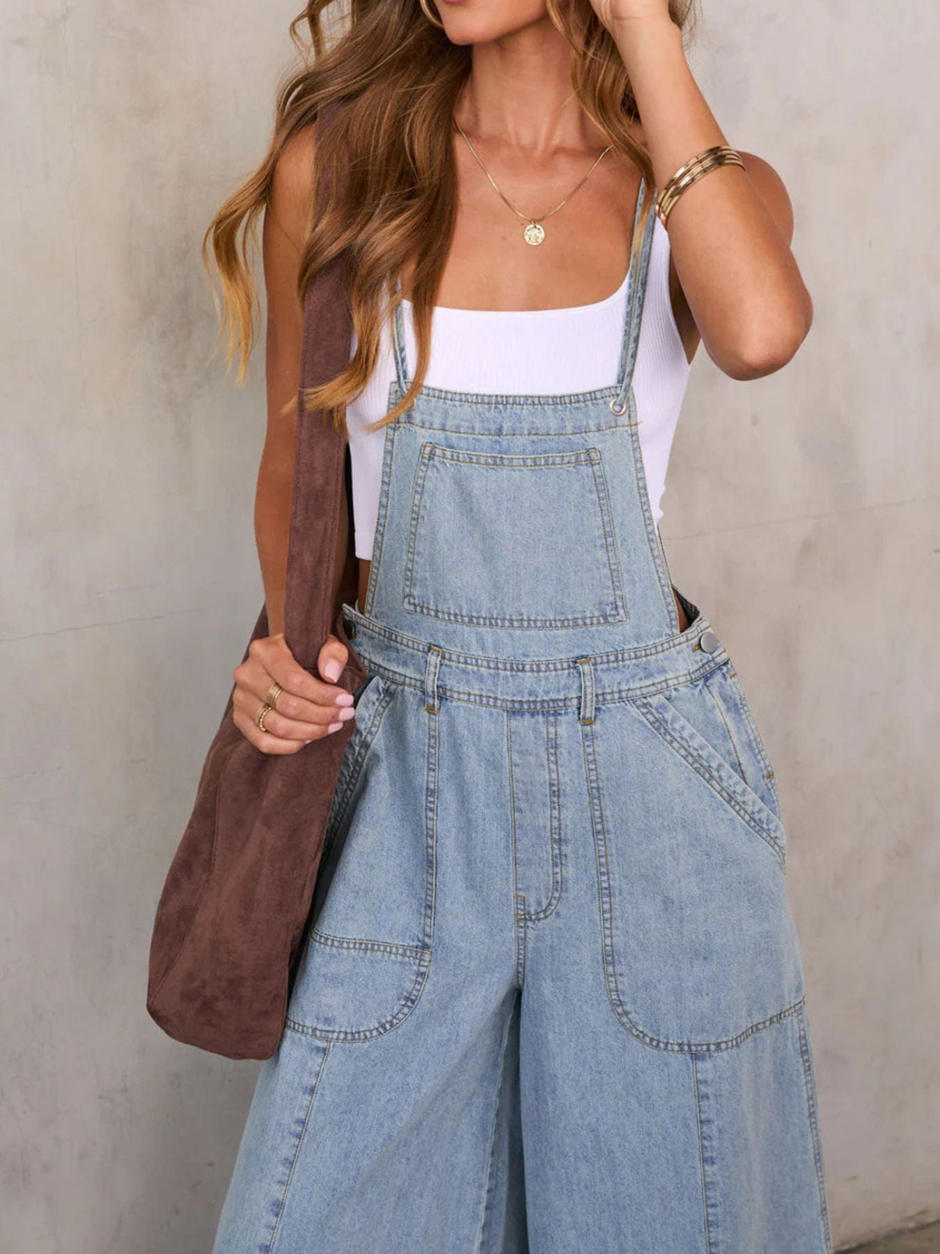 Women's relaxed fit wide leg denim overalls jumpsuit made of comfortable cotton blend, featuring adjustable straps and front pockets.