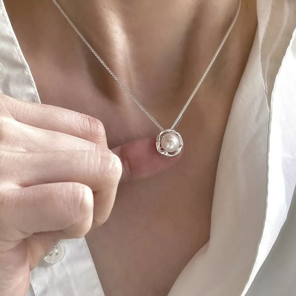 Sterling silver pearl pendant necklace featuring a smooth white pearl on a delicate chain, elegant jewelry accessory.