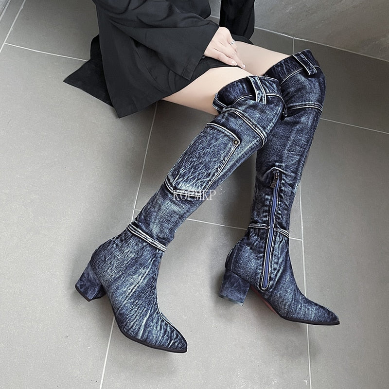 Blue denim over-the-knee block-heel boots with side zippers, pockets, and belt loops at the cuffs.