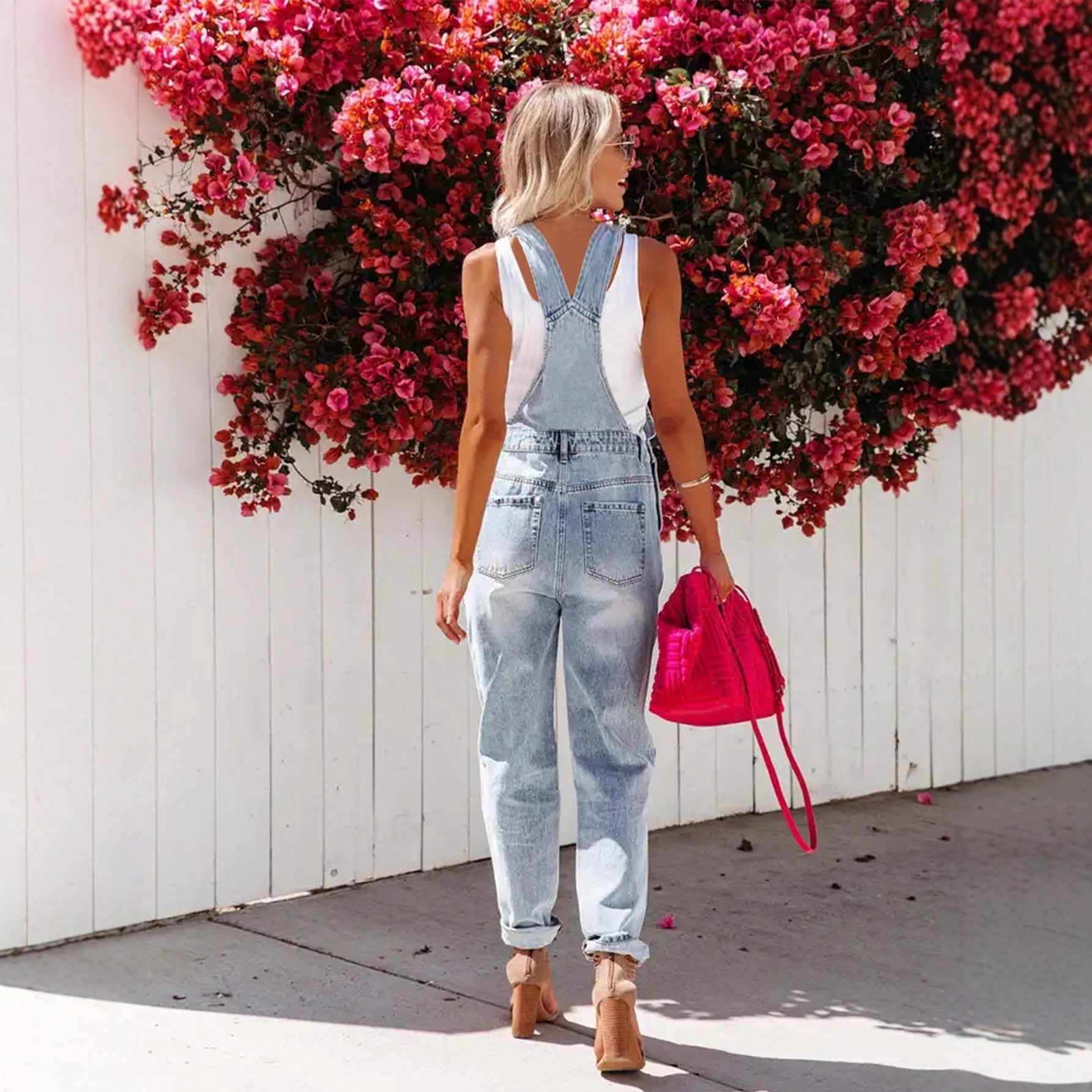 Women's cropped ripped denim overalls by FitiqueFit featuring streetwear strap bib design and distressed detailing.