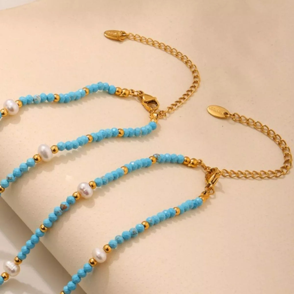 Turquoise pearl beaded necklace from Shopimist featuring round beads and a delicate design on a white background.