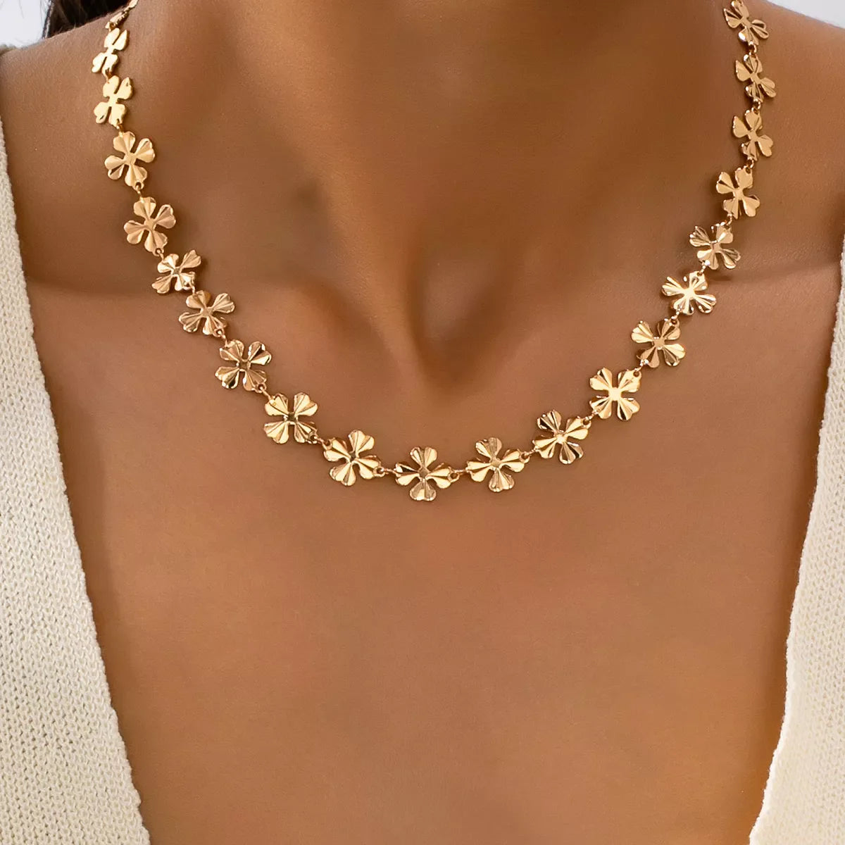 Gold-plated alloy flower chain necklace with delicate floral design, styled as a jewelry accessory on a white background.