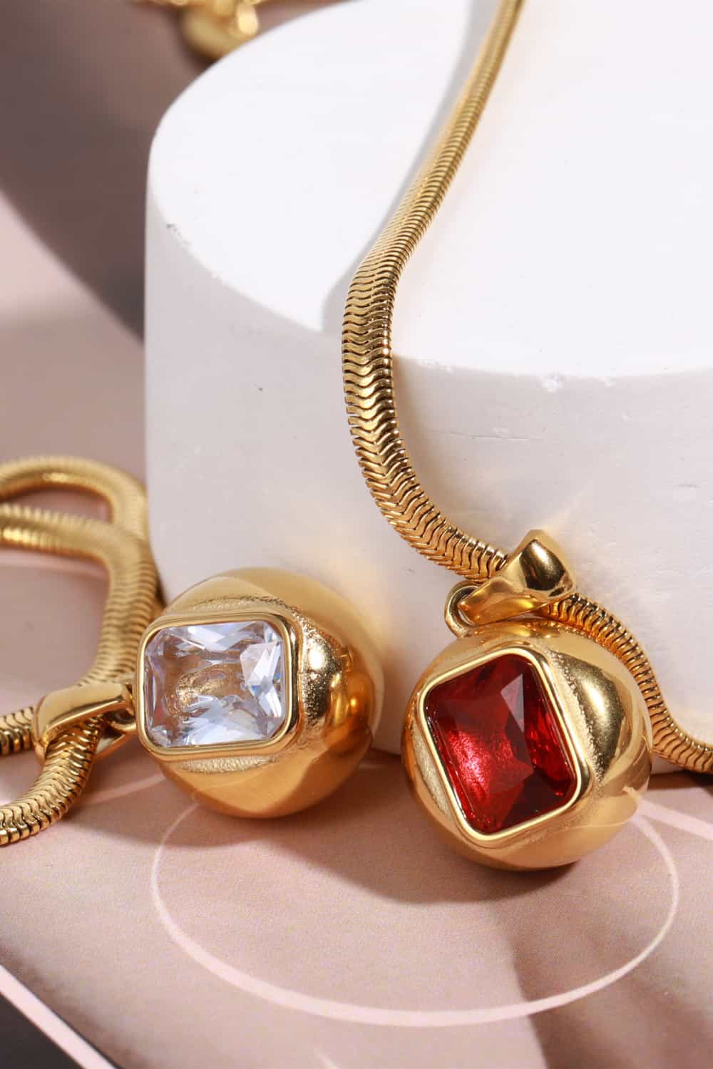 Zircon 18K gold-plated geometrical shape pendant necklace with sleek modern design, displayed close-up on a white background.