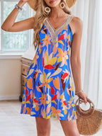 Tropical leaf print sleeveless V-neck dress by Shopimist, showing vibrant green and yellow foliage on lightweight fabric.
