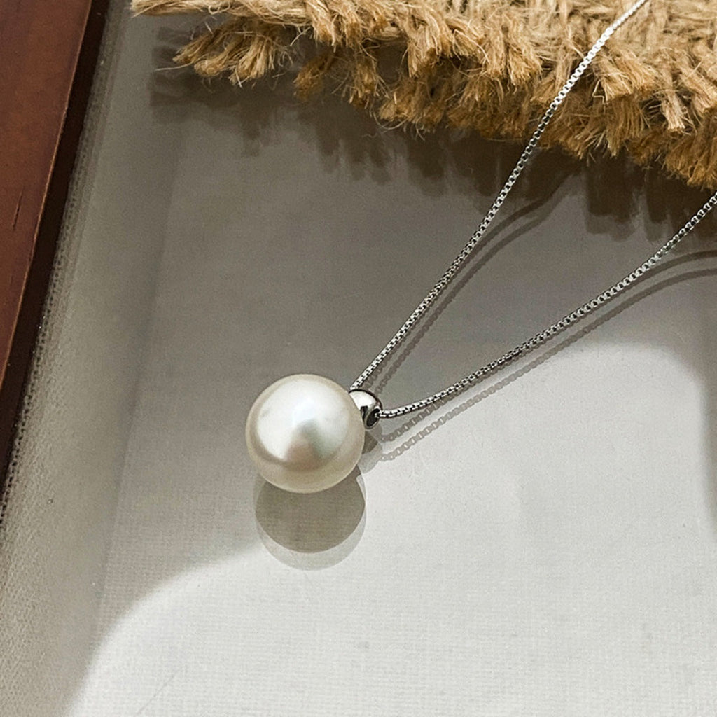 Sterling silver pearl pendant necklace featuring a round white pearl on a delicate silver chain, stylish and elegant jewelry.