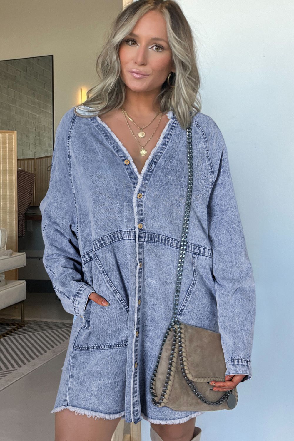 Long sleeve button-down denim dress with raw hem from Plush Fashion Hub, featuring a casual, stylish silhouette.