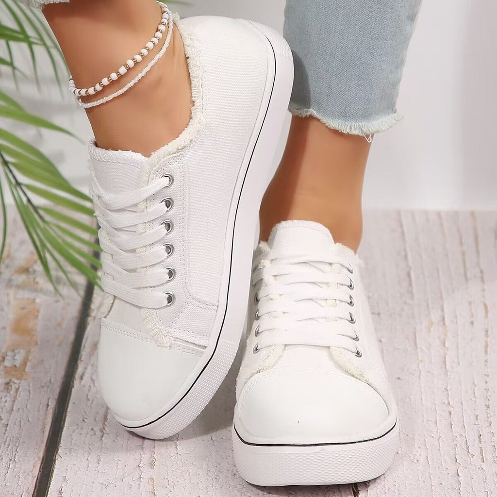 Women's lightweight lace-up canvas sneakers with flat low-top design by Plush Fashion Hub, showing white shoes with laces and rubber soles.
