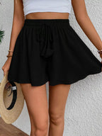 Flowy drawstring waist romper shorts from Trendsi, featuring a lightweight, relaxed fit with adjustable waist ties and casual style.