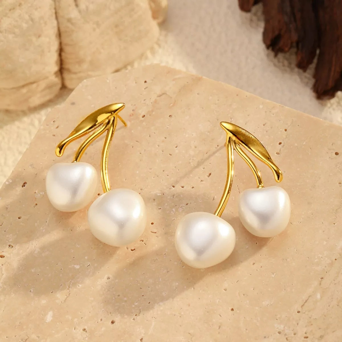 Pearl cherry drop earrings by Shopimist featuring pearl and red cherry-shaped charms on delicate gold hooks.