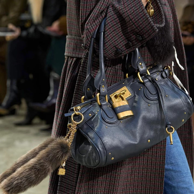 Vintage distressed plush fashion hub padlock handbag for women, handheld crossbody bag with a retro style and secure closure.