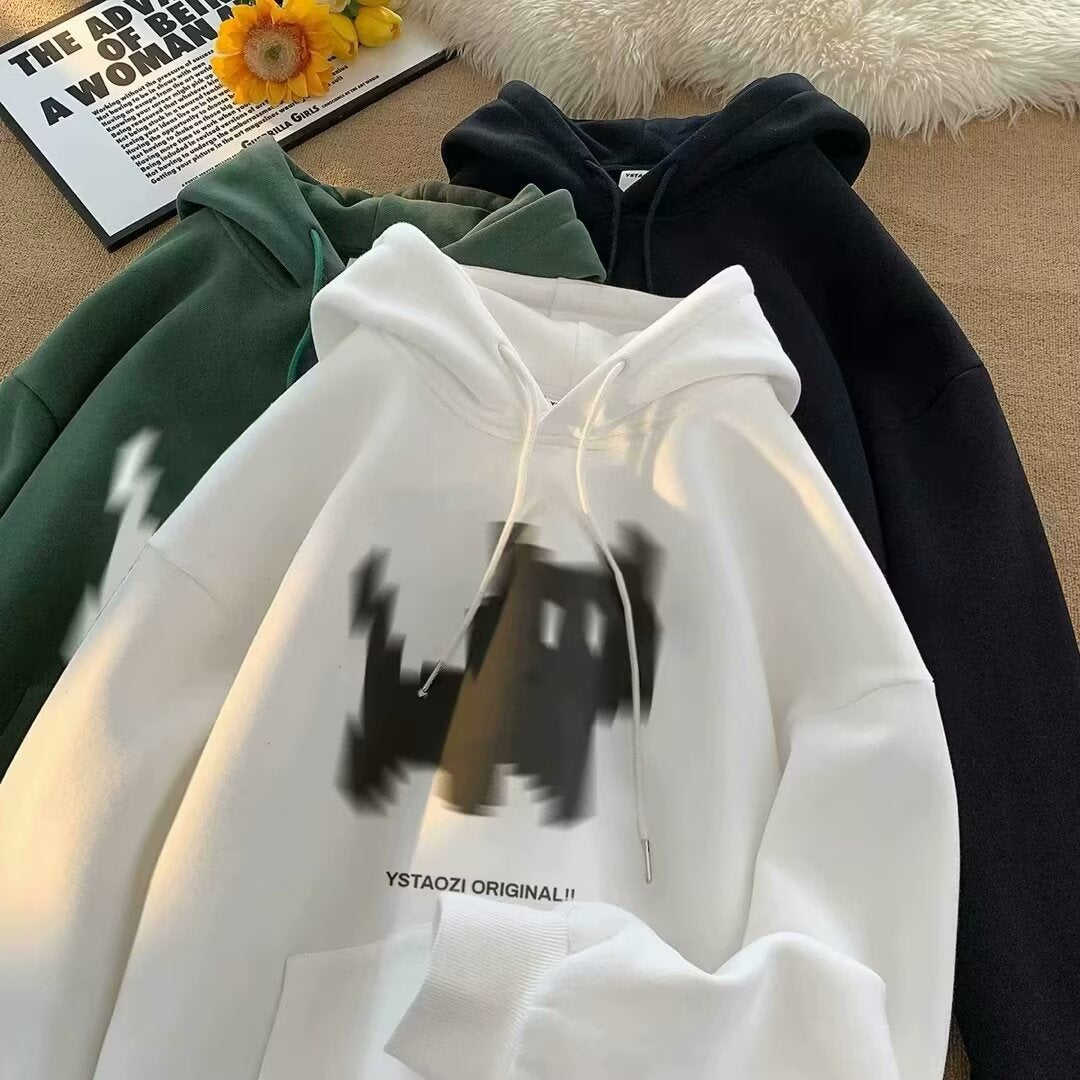 Three fleece hoodies in white, green, and black with drawstring hoods, kangaroo pockets, and graphic prints.