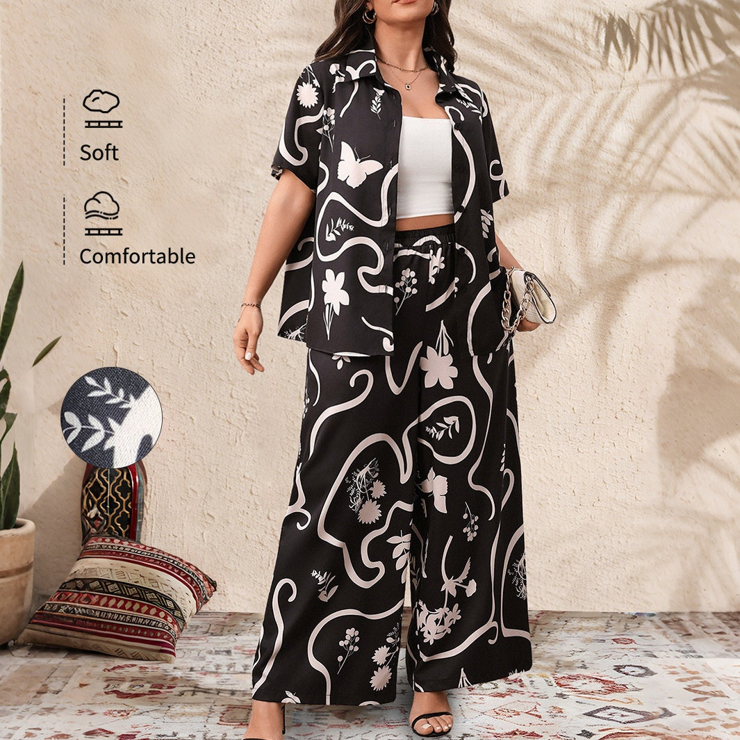 A black and white printed two-piece outfit featuring a short-sleeved button-up shirt and wide-leg trousers.