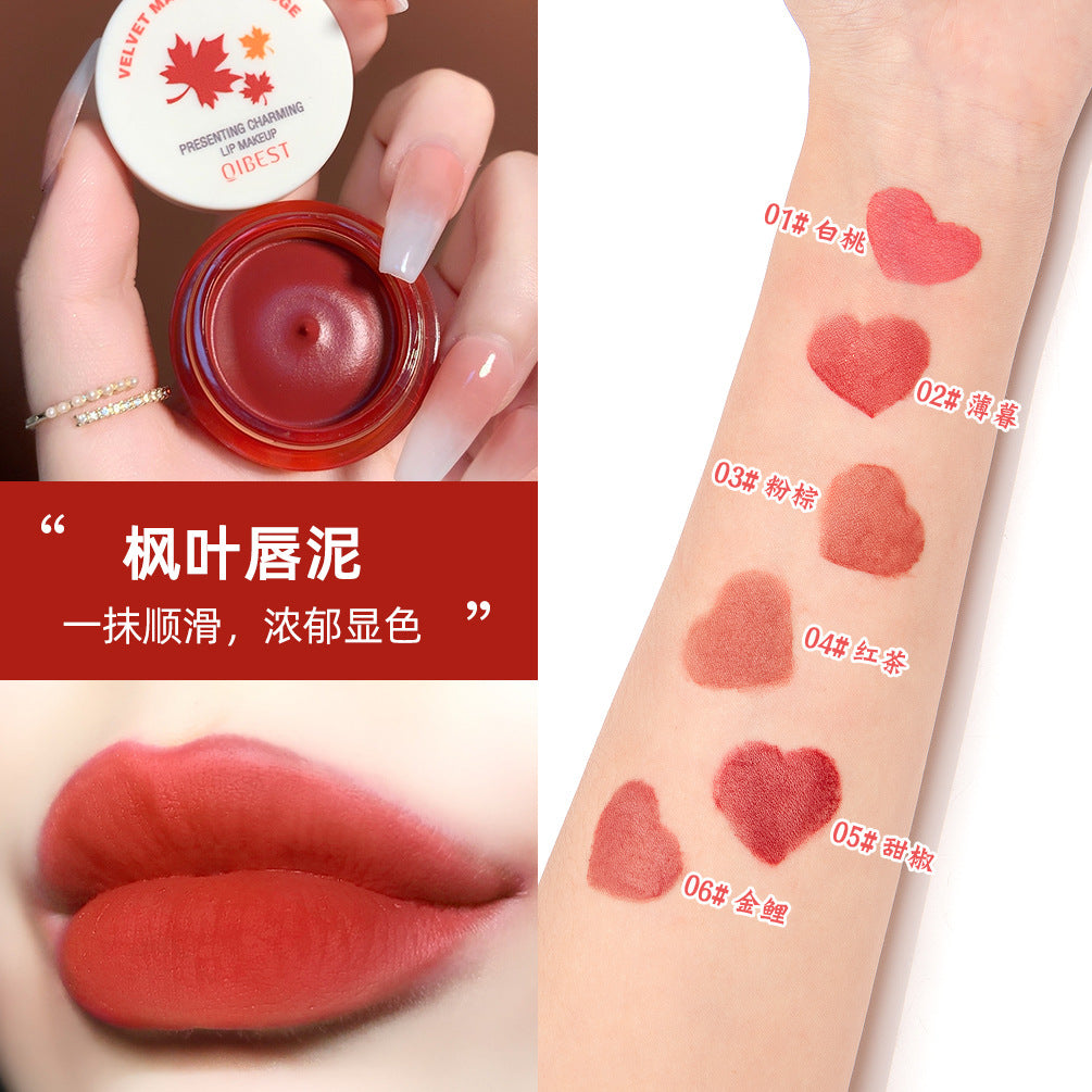 Round red lip mud jar with white cap, swatches on arm in heart shapes, and matte lips.