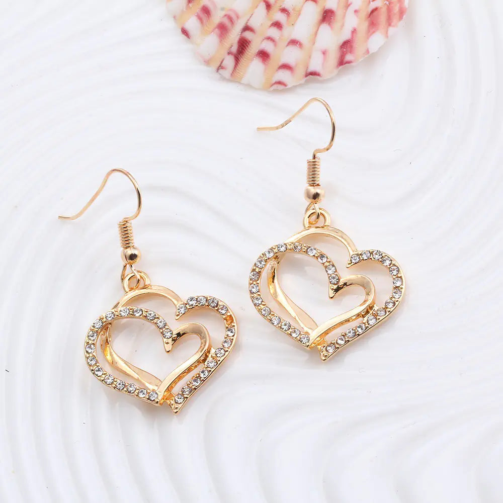 Double heart earrings and necklace wedding jewelry set featuring silver-tone hearts and delicate chain details.