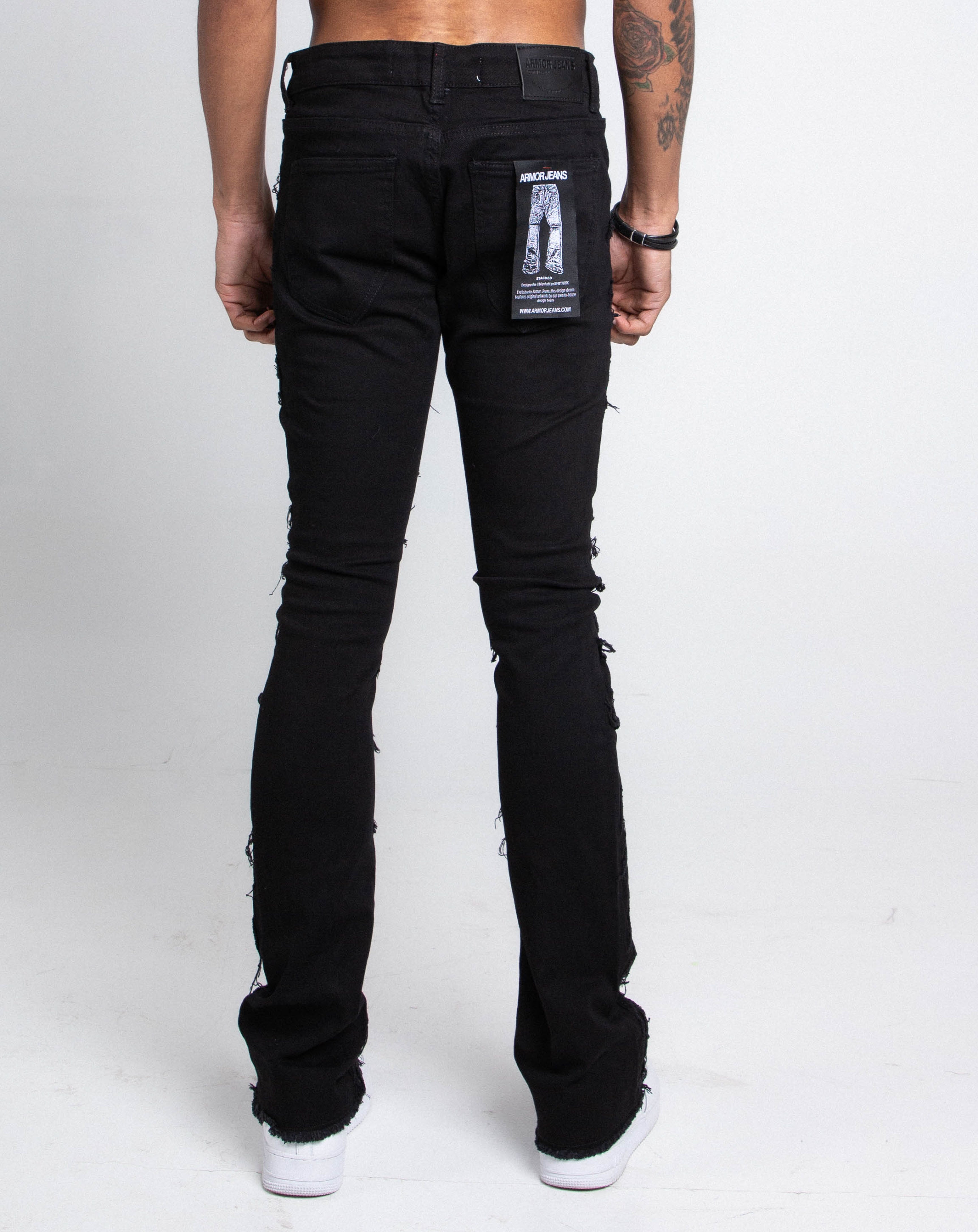 A pair of Armor Jeans AJS410 shredded stacked jeans pants with distressed detailing and a slim fit, displayed on a plain background.