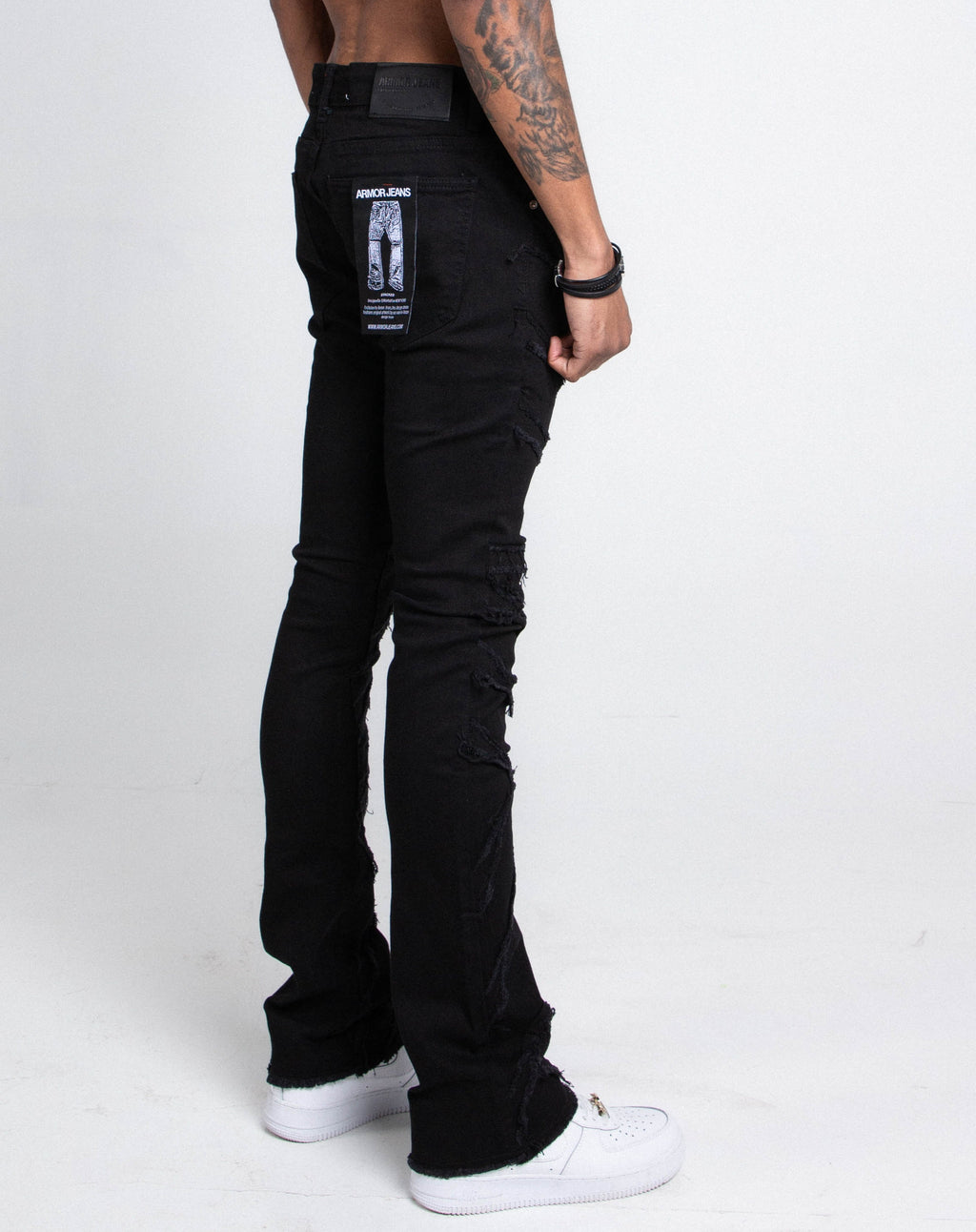 A pair of Armor Jeans AJS410 shredded stacked jeans in distressed denim with layered, torn design and slim fit style.