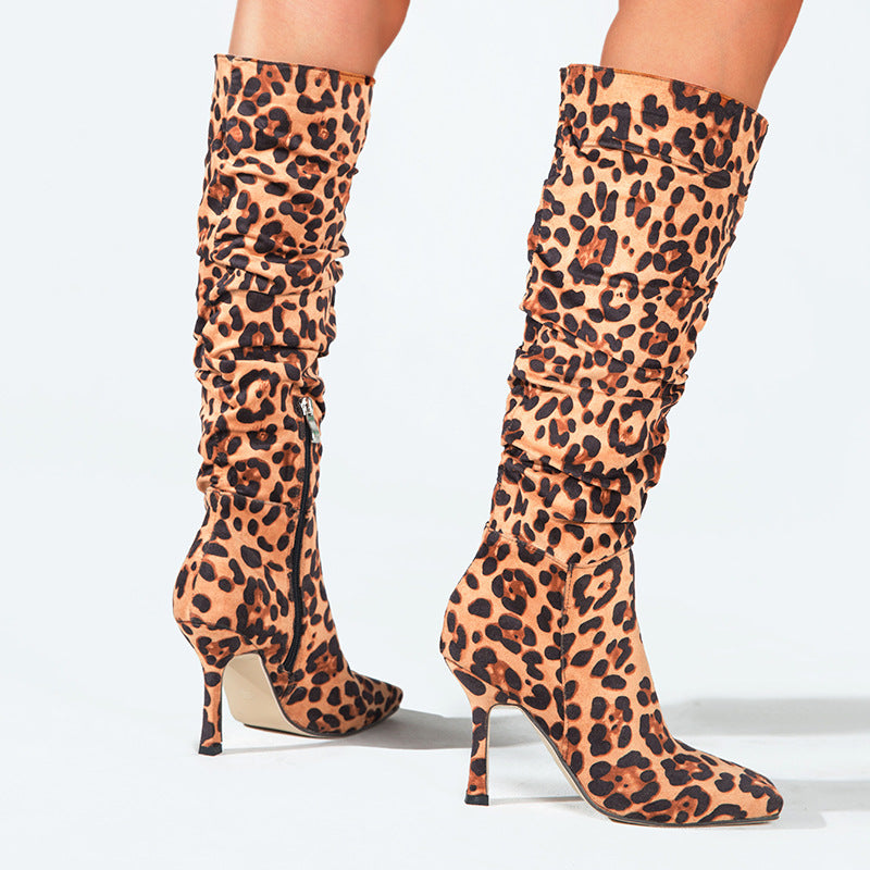 Tan and black leopard-print suede knee-high boots with pointed toes, stiletto heels, and ruching.