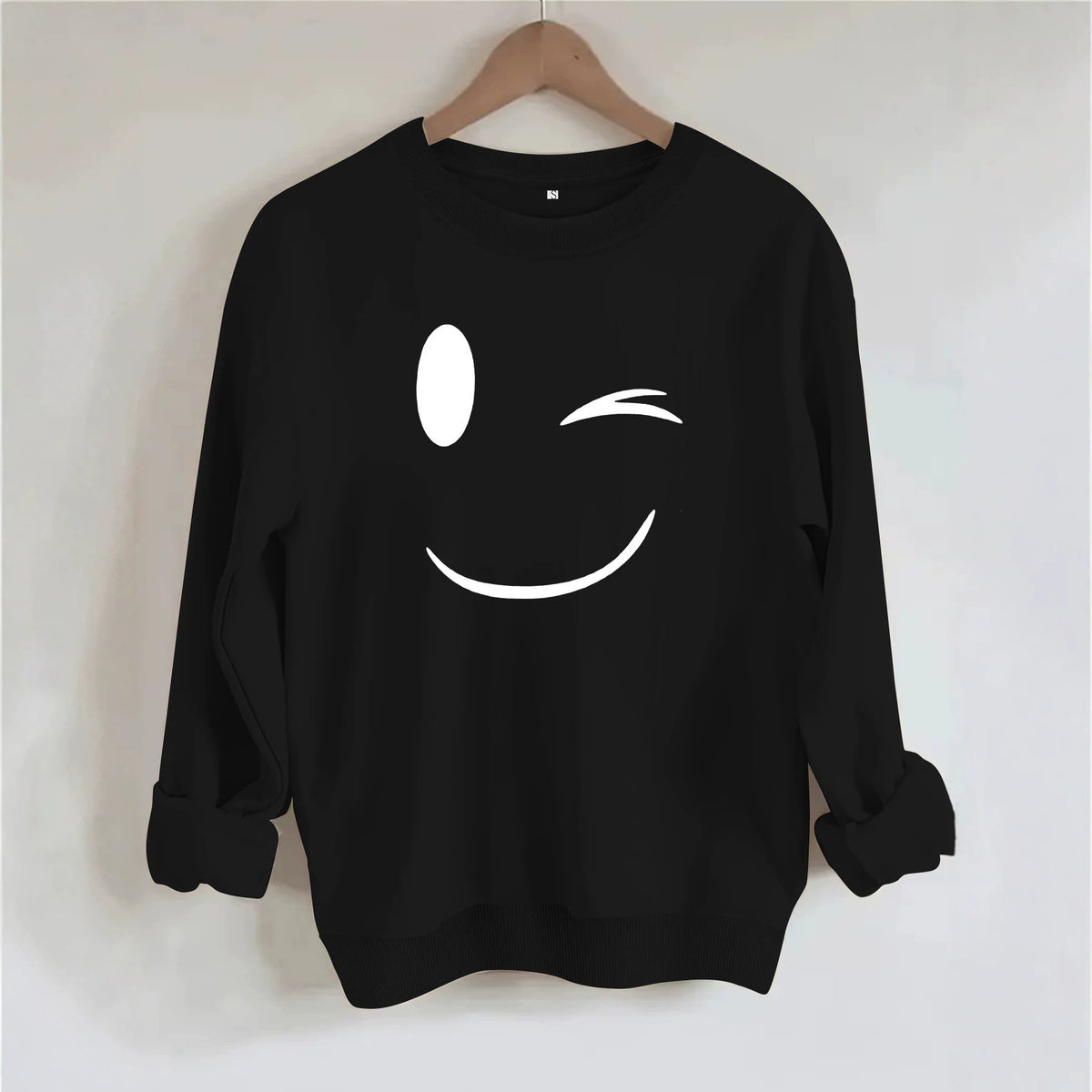 Black knit cotton sweatshirt with a white winking face graphic on the chest.