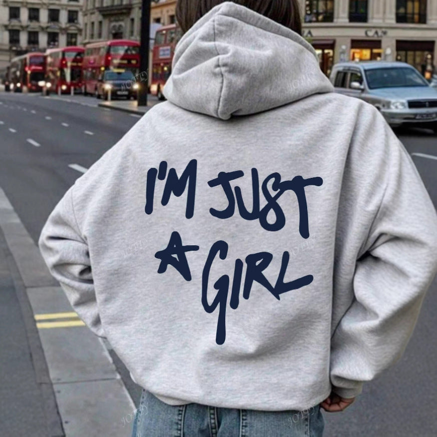 Light gray cotton-blend hoodie with back text reading "I'M JUST A GIRL" in dark blue.