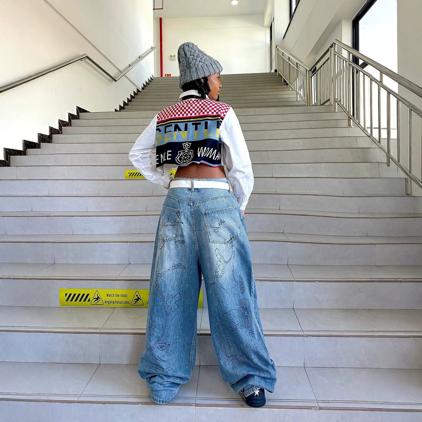 Eprolo graffiti print washed denim jeans with distressed details, front and back pockets, and a relaxed fit.