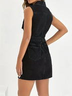 Denim mini dress with button front and fringe detail, trendy button-front denim dress by Trendsi displayed on a model.