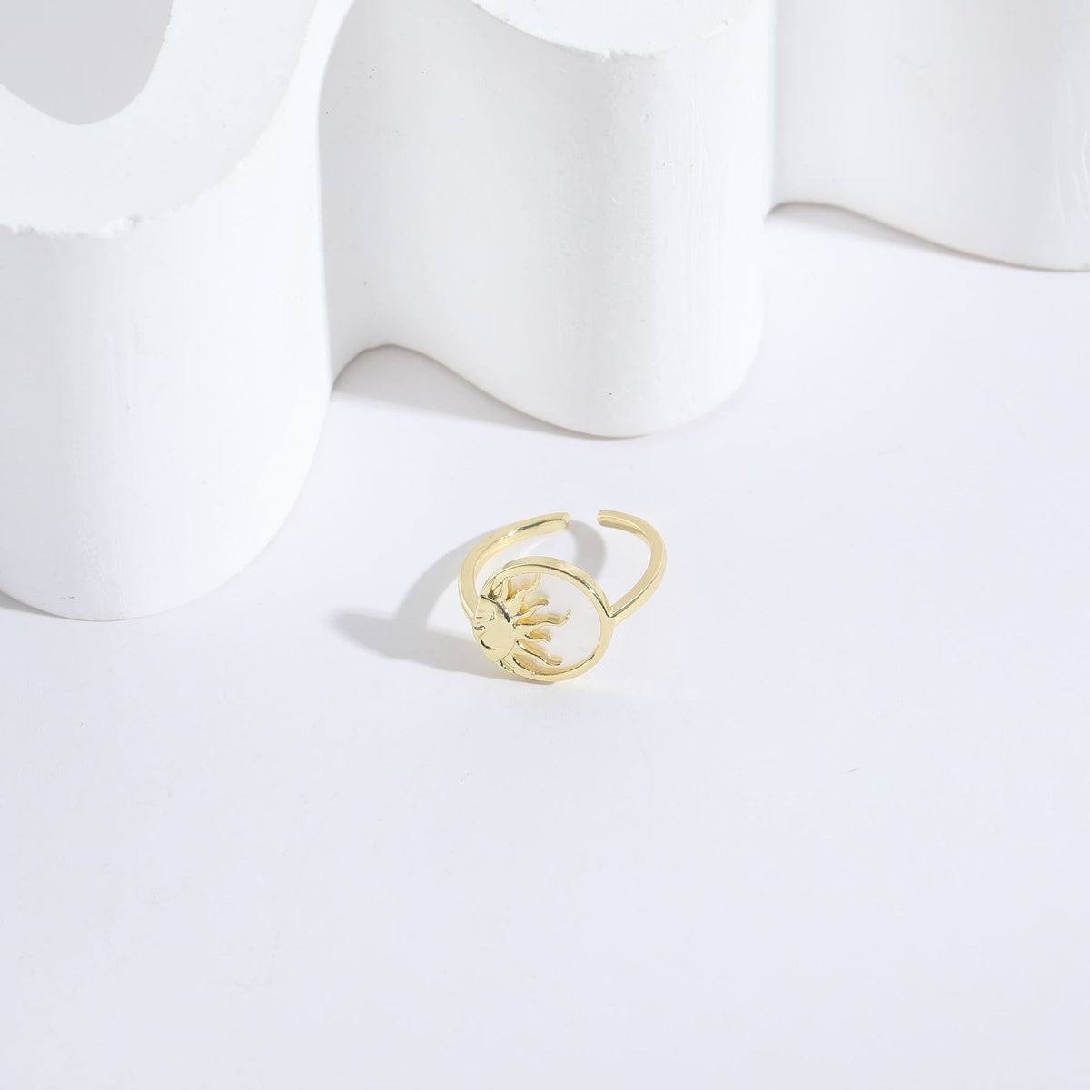 Gold metal ring with an open band featuring a sun-and-moon cutout design.