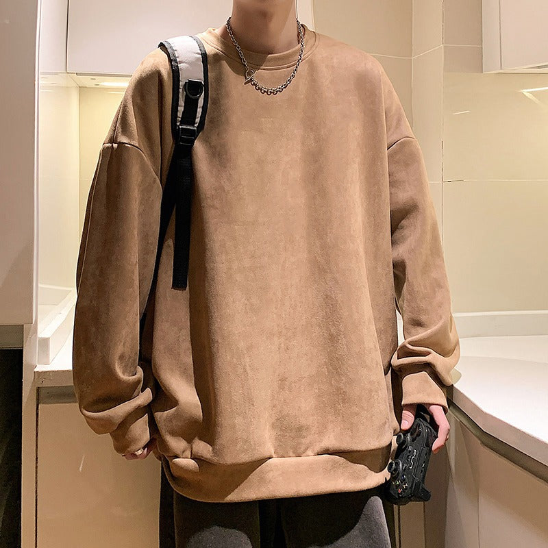 A camel brown suede crewneck sweatshirt in a casual, oversized style, paired with a silver chain necklace.