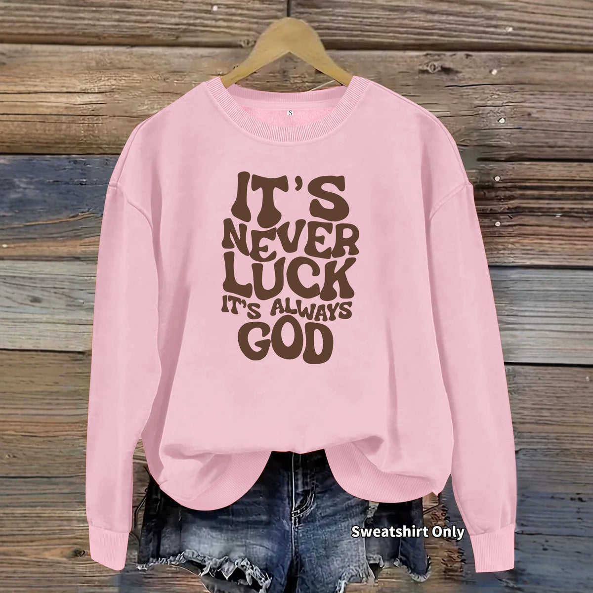 Pink cotton-blend crewneck sweatshirt with the brown retro text “IT'S NEVER LUCK IT'S ALWAYS GOD.”