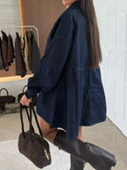 Casual mini denim dress with button-down front and front pockets, styled by Trendsi, featuring a relaxed fit and classic denim look.