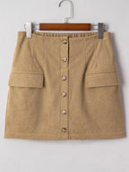 Women's high-waisted corduroy mini skirt with button front in a plush fashion shop, showcasing a stylish and comfortable design.
