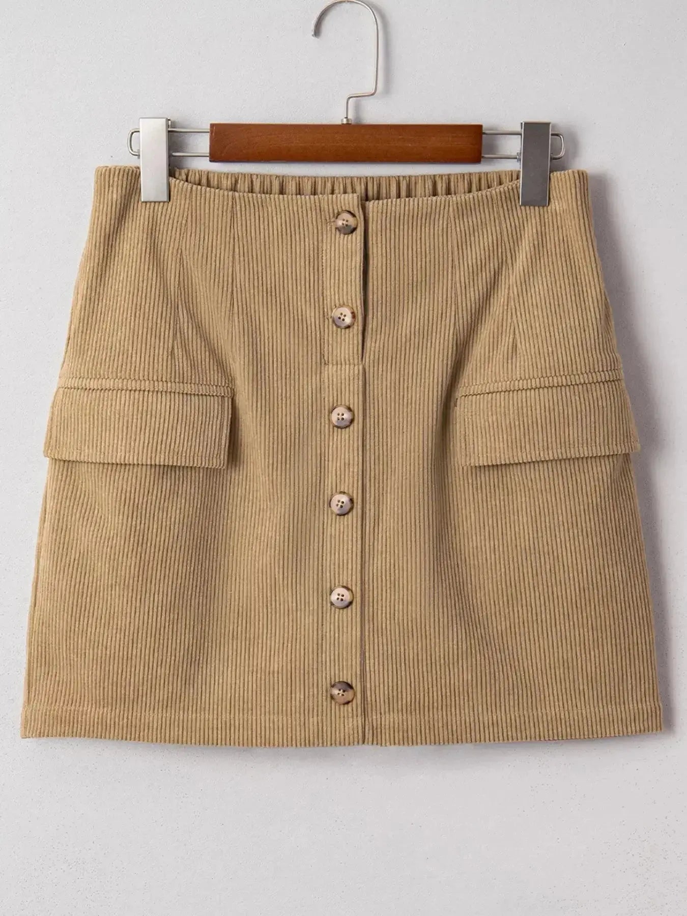 Women's high-waisted corduroy mini skirt with button front in a plush fashion shop, showcasing a stylish and comfortable design.
