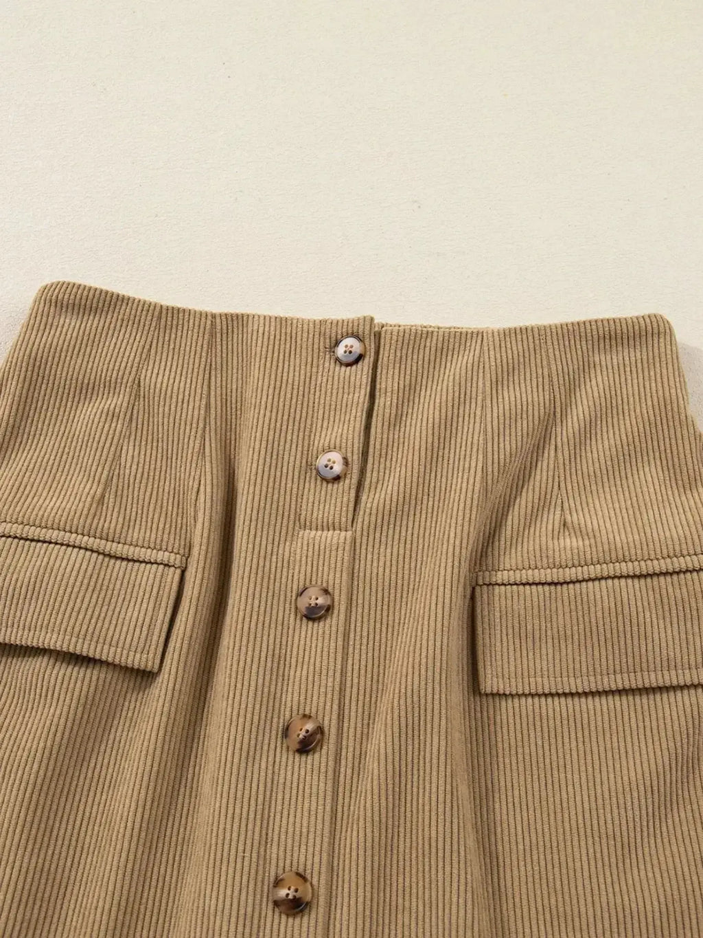 Women's high-waisted corduroy mini skirt with button front from Plush Fashion Hub, shown in a stylish, close-up view.