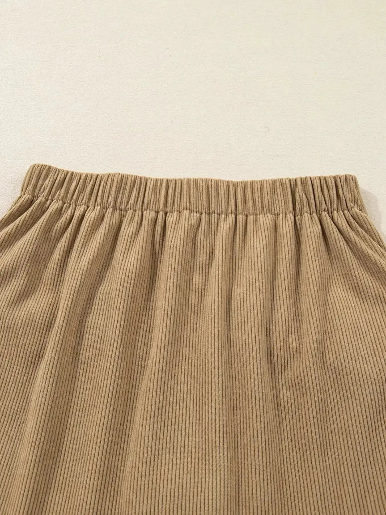 Women's high-waisted corduroy mini skirt with button front in a stylish, textured design by Plush Fashion Hub.